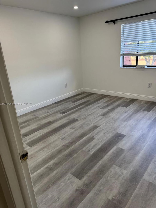 unfurnished room with hardwood / wood-style floors