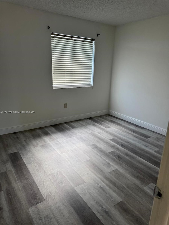 10800 NW 7th St Unit 3B, Miami, FL 33172 - unfurnished room featuring baseboards, wood finished floors, and a textured ceiling