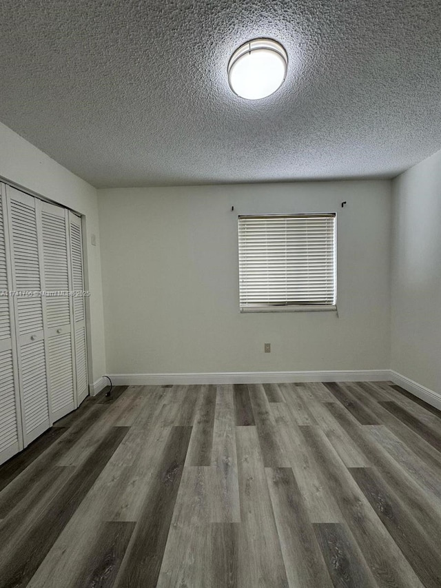 10800 NW 7th St Unit 3B, Miami, FL 33172 - unfurnished bedroom with baseboards, wood finished floors, a textured ceiling, and a closet