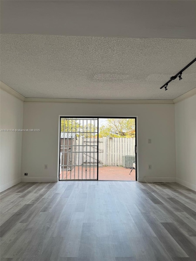 10800 NW 7th St Unit 3B, Miami, FL 33172 - unfurnished room with track lighting, wood finished floors, a textured ceiling, and baseboards