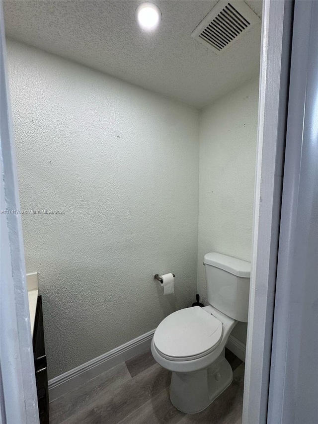 10800 NW 7th St Unit 3B, Miami, FL 33172 - bathroom featuring baseboards, wood finished floors, visible vents, and toilet