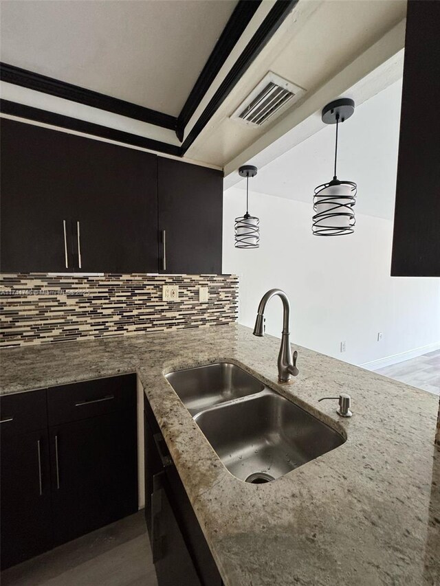 10800 NW 7th St Unit 3B, Miami, FL 33172 - kitchen with dark cabinets, visible vents, a sink, decorative light fixtures, and light stone countertops