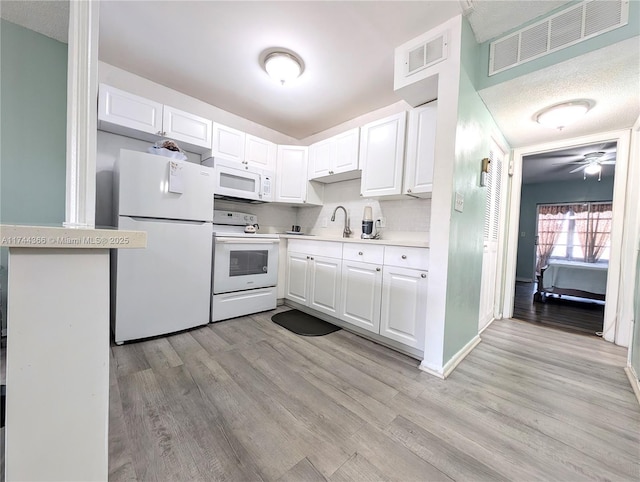 kitchen featuring white cabinetry, white appliances, and light hardwood / wood-style floors