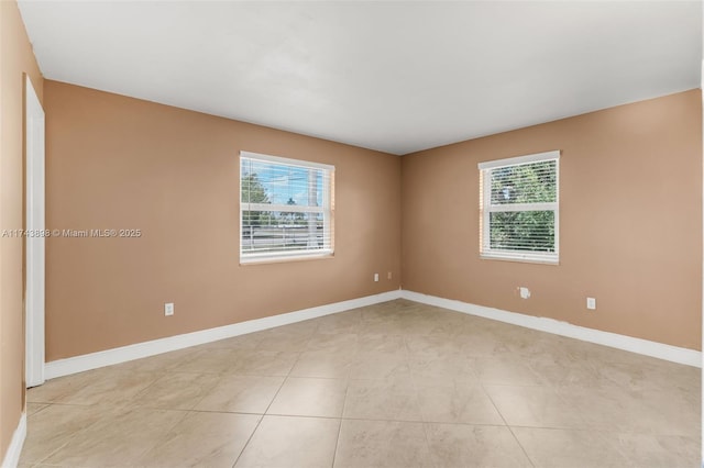 empty room featuring plenty of natural light and light tile patterned floors