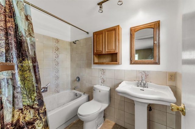 bathroom featuring shower / bathtub combination with curtain, toilet, and tile walls