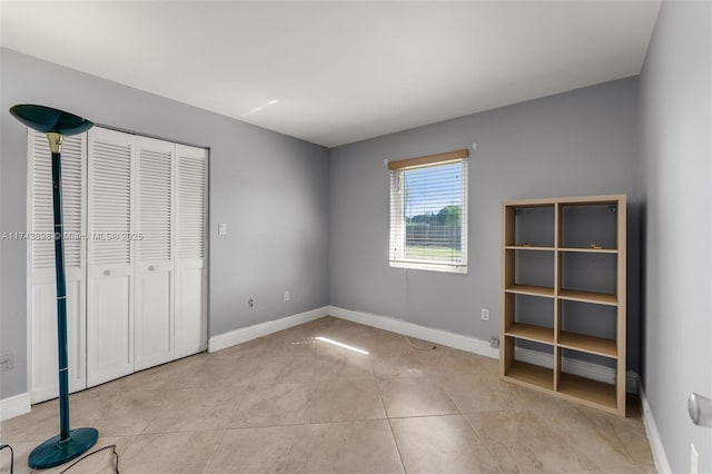 unfurnished bedroom featuring light tile patterned floors and a closet