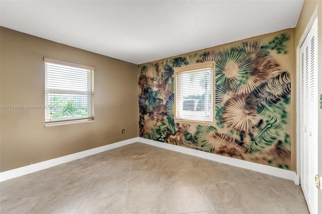 spare room featuring a healthy amount of sunlight and light tile patterned floors