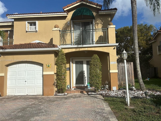 view of front facade with a tile roof, a balcony, and stucco siding