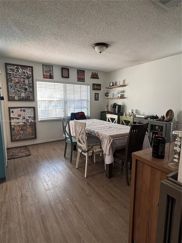 dining room with hardwood / wood-style floors and a textured ceiling