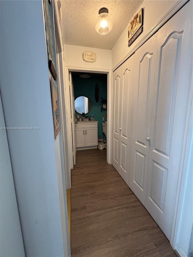 hallway featuring dark hardwood / wood-style floors and a textured ceiling