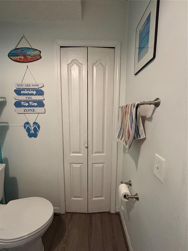 bathroom with hardwood / wood-style floors and toilet