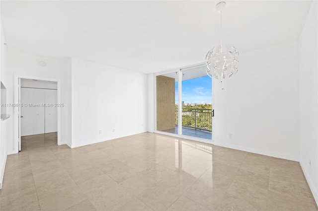 spare room featuring floor to ceiling windows, baseboards, and an inviting chandelier