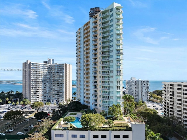 view of building exterior featuring a water view and a city view