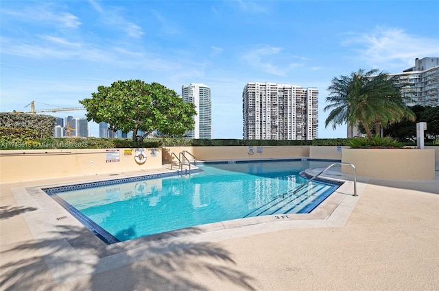 community pool with a view of city and a patio