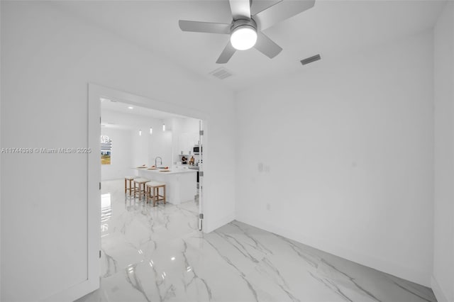 unfurnished room featuring sink and ceiling fan