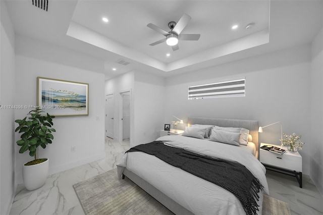 bedroom with a raised ceiling and ceiling fan