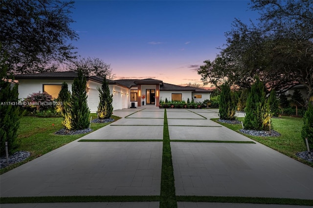 view of front facade with a garage and a lawn