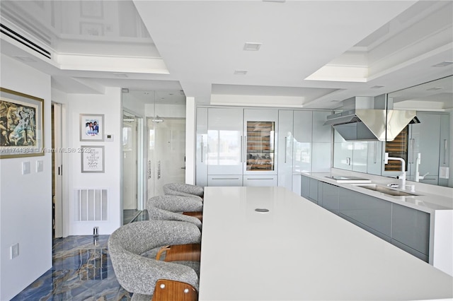 kitchen with visible vents, modern cabinets, light countertops, gray cabinetry, and a sink