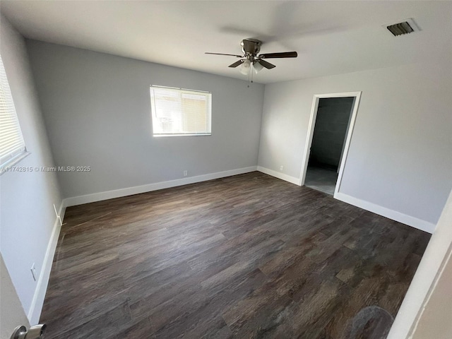 empty room with ceiling fan and dark hardwood / wood-style flooring