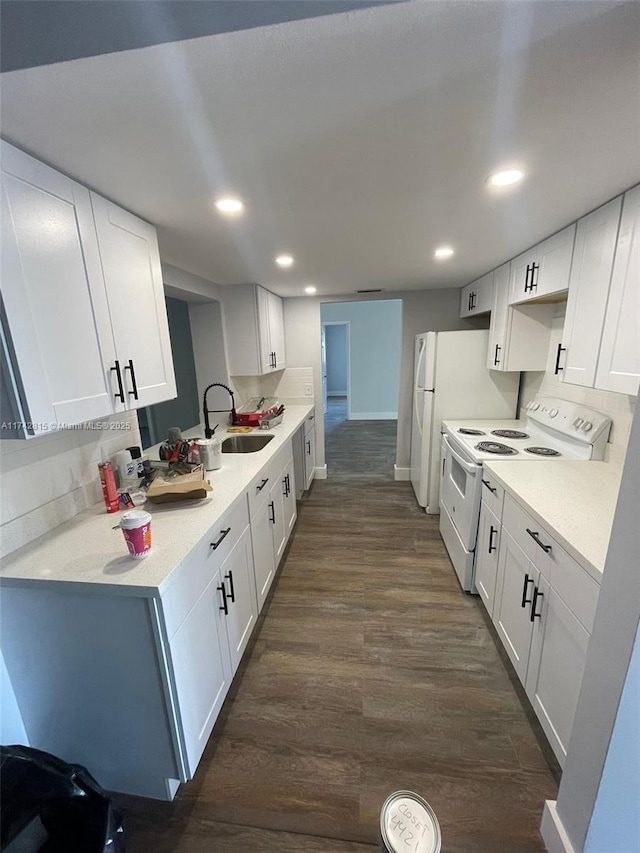 kitchen featuring electric stove, sink, dark wood-type flooring, white cabinets, and kitchen peninsula