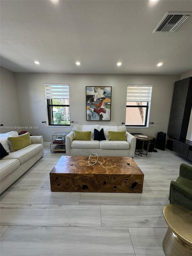 living room featuring a textured ceiling and light hardwood / wood-style flooring