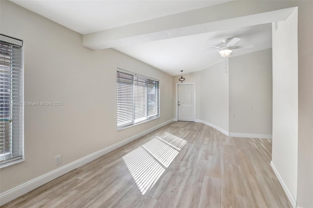 spare room featuring ceiling fan, lofted ceiling with beams, and light wood-type flooring