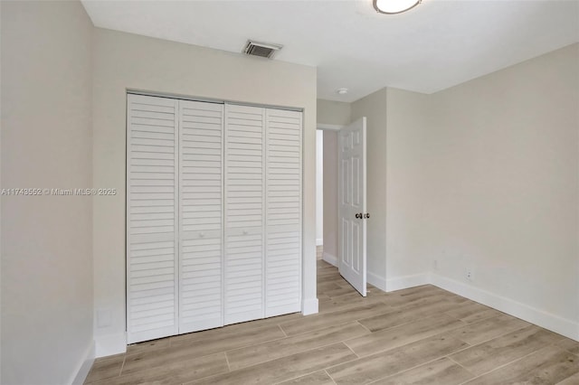 unfurnished bedroom featuring a closet and light wood-type flooring