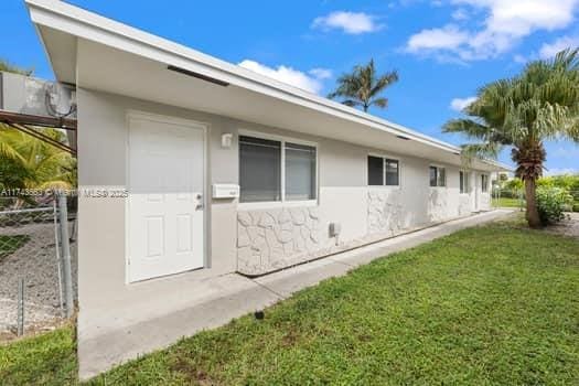 view of side of home featuring a yard and stucco siding