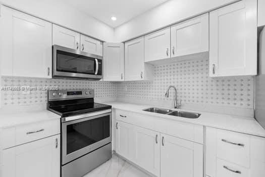 1431-1433 N 14th Way, Hollywood, FL 33020 - kitchen featuring appliances with stainless steel finishes, light countertops, and white cabinets