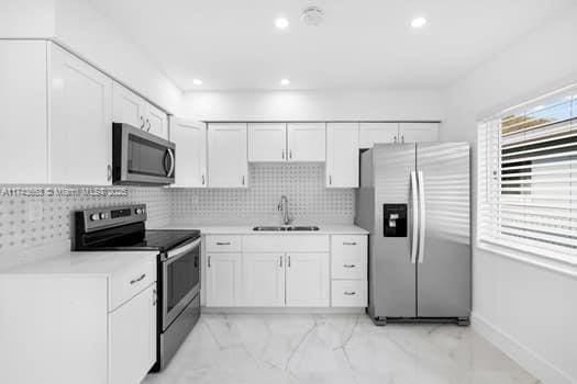 1431-1433 N 14th Way, Hollywood, FL 33020 - kitchen with stainless steel appliances, light marble finish floors, light countertops, white cabinets, and recessed lighting