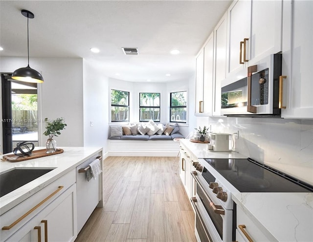 kitchen featuring light stone countertops, white appliances, white cabinetry, and decorative light fixtures