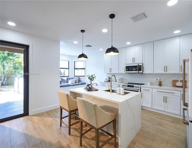 kitchen with a kitchen island with sink, light countertops, electric range, and white microwave