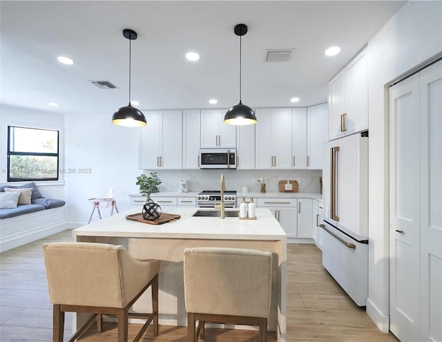 kitchen featuring white cabinets, white appliances, light countertops, and hanging light fixtures