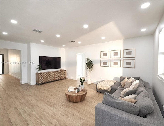 living room featuring light wood-style flooring, visible vents, and recessed lighting