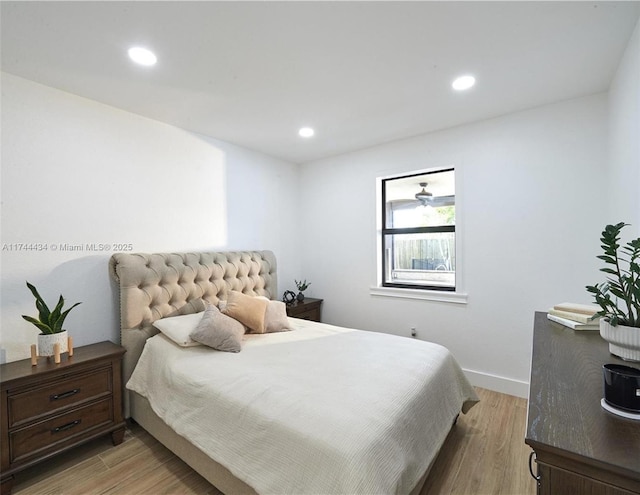 bedroom with baseboards, wood finished floors, and recessed lighting