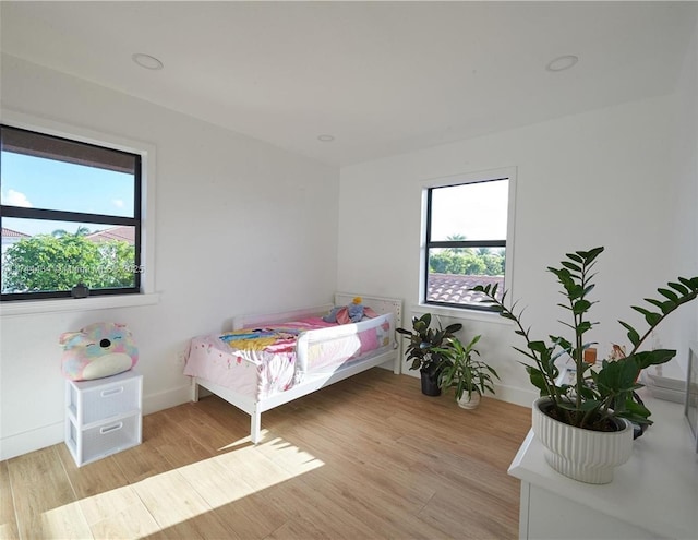 bedroom featuring light wood-style floors and baseboards