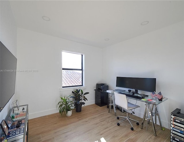 office area featuring light wood-type flooring and baseboards