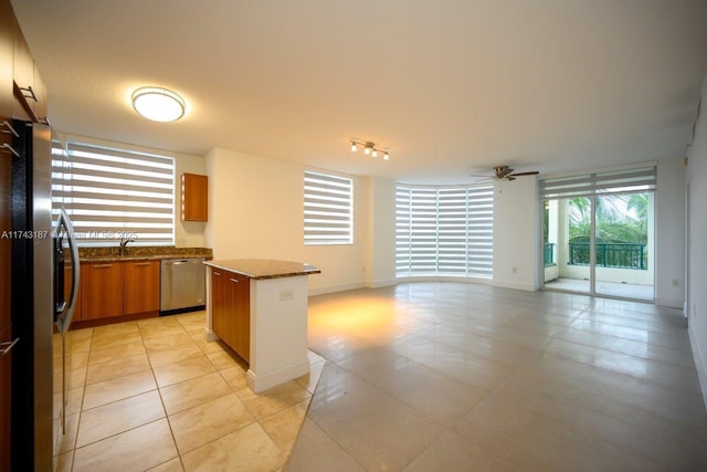 510 NW 84th Ave Unit 409, Plantation, FL 33324 - kitchen with appliances with stainless steel finishes, a kitchen island, light tile patterned flooring, a ceiling fan, and brown cabinets