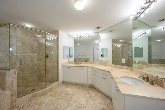 full bathroom with double vanity, a sink, a stall shower, and visible vents