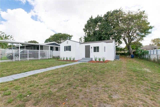 view of front of house with a front yard and central air condition unit