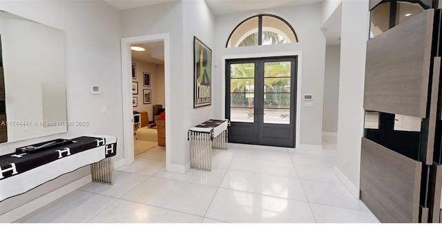 entrance foyer featuring french doors, baseboards, and light tile patterned floors