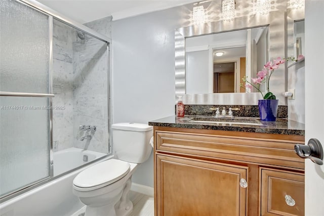 full bath featuring toilet, combined bath / shower with glass door, and vanity