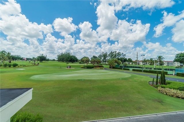 surrounding community with view of golf course and a lawn