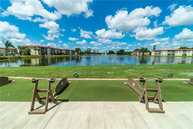 view of home's community with a patio area, a yard, and a water view