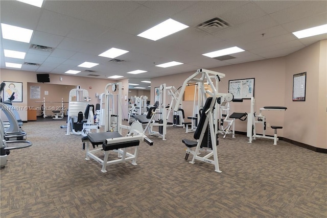 workout area featuring a paneled ceiling, visible vents, and dark carpet