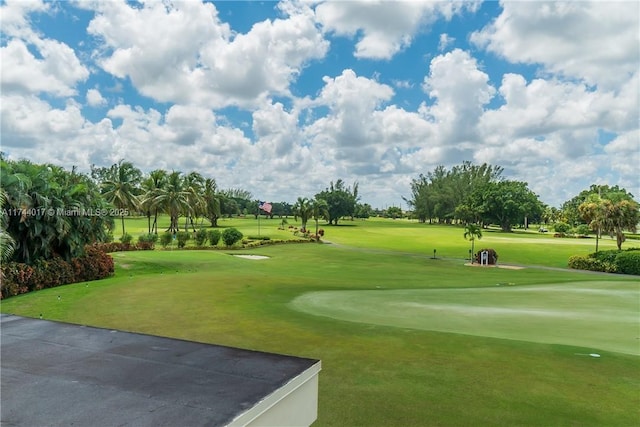 view of community with view of golf course and a lawn