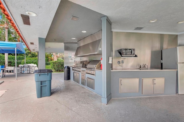 view of patio with visible vents, an outdoor kitchen, a sink, and area for grilling