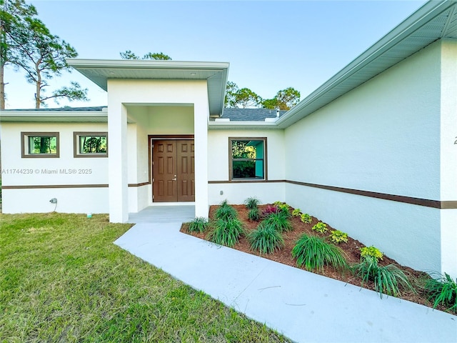 doorway to property featuring a lawn