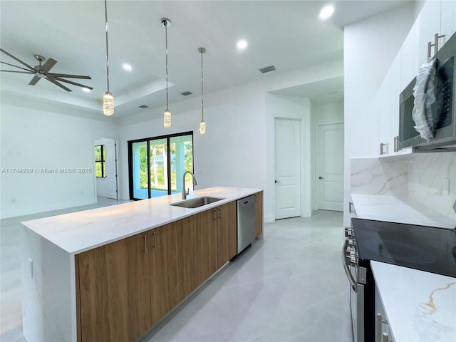 kitchen featuring sink, white cabinetry, appliances with stainless steel finishes, a tray ceiling, and pendant lighting