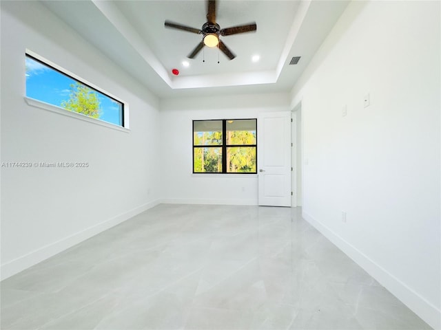 unfurnished room featuring a tray ceiling and ceiling fan